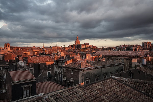 The sun rises over the roofs of Catania