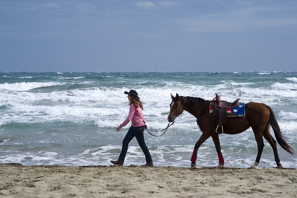 woman and horse on a beach in Italy